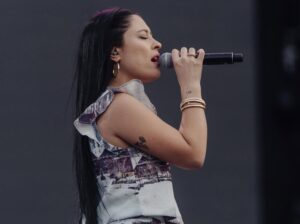 Valentina Márquez cantando en show con un vestido gris 