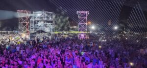 Panorámica del escenario iluminado con luces violetas durante el show de Rusher King para Ternium