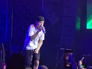 Lit Killah cantando en vivo con remera blanca y gorra negra